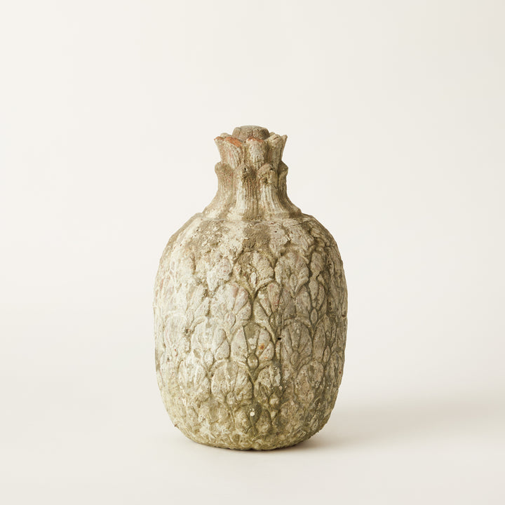 Textured stone cement pineapple form on a light background