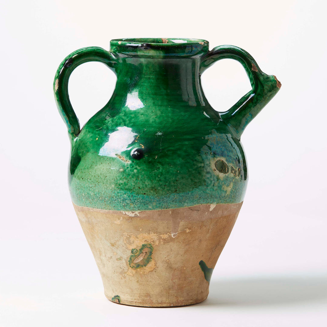 Green ceramic vase with brown base on a white background