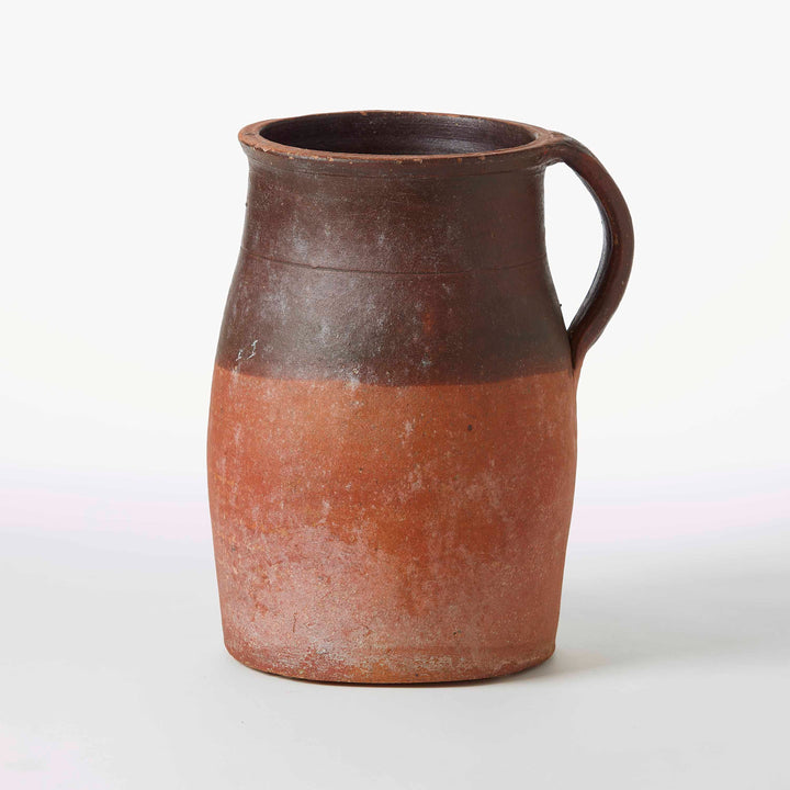 Ceramic pitcher with a brown top and red-brown bottom on a white background