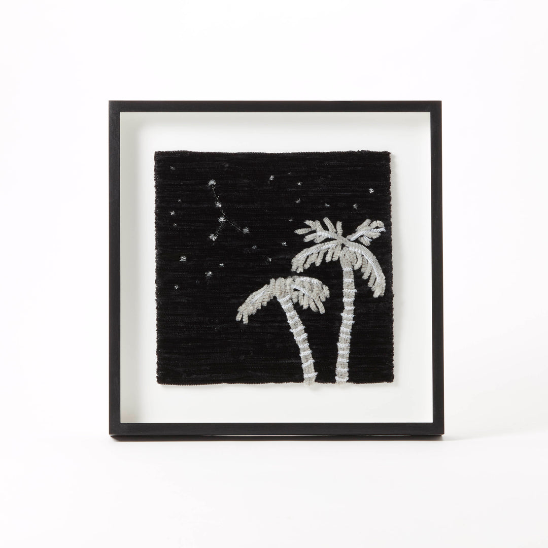 Framed artwork with palm trees and stars on a black background