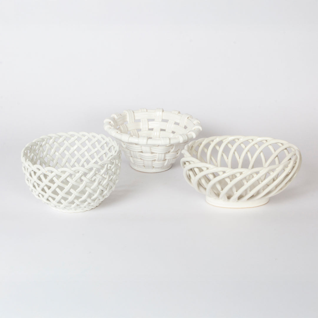 Three small white decorative baskets with woven lattice patterns, arranged on a seamless white background.