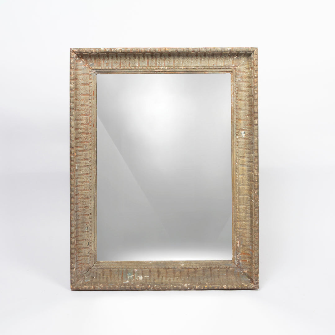 A rectangular wall mirror with an ornate, distressed textured frame in a weathered beige and brown finish, set against a plain white background.