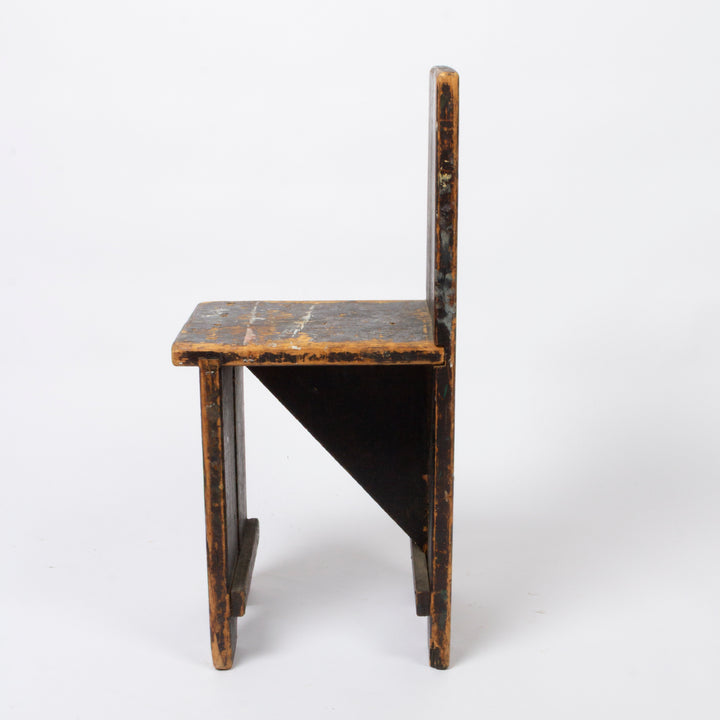 A small rustic wooden chair with a high back, featuring a distressed brown and black finish, photographed against a plain white background.