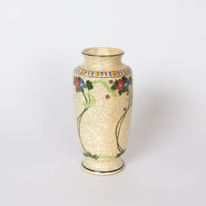 A vintage-style ceramic vase with a cream-colored crackled glaze, decorated with a colorful floral vine pattern and a geometric border at the neck