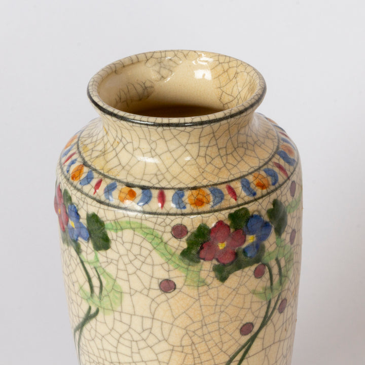 A ceramic vase with a cream-colored glaze featuring a crackle pattern, decorated with hand-painted flowers in red, blue, and purple with green leaves and stems.