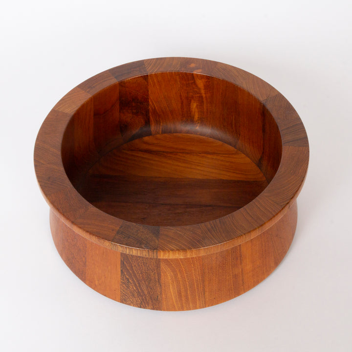A round wooden salad bowl with a thick pedestal base, crafted from dark brown wood with visible grain patterns, photographed on a clean white background.