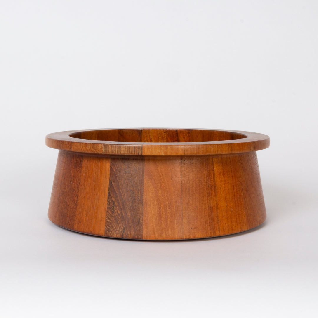 A round wooden salad bowl with a wide rim and a tapered base, crafted from warm medium-brown wood with visible grain patterns, set against a plain white background.
