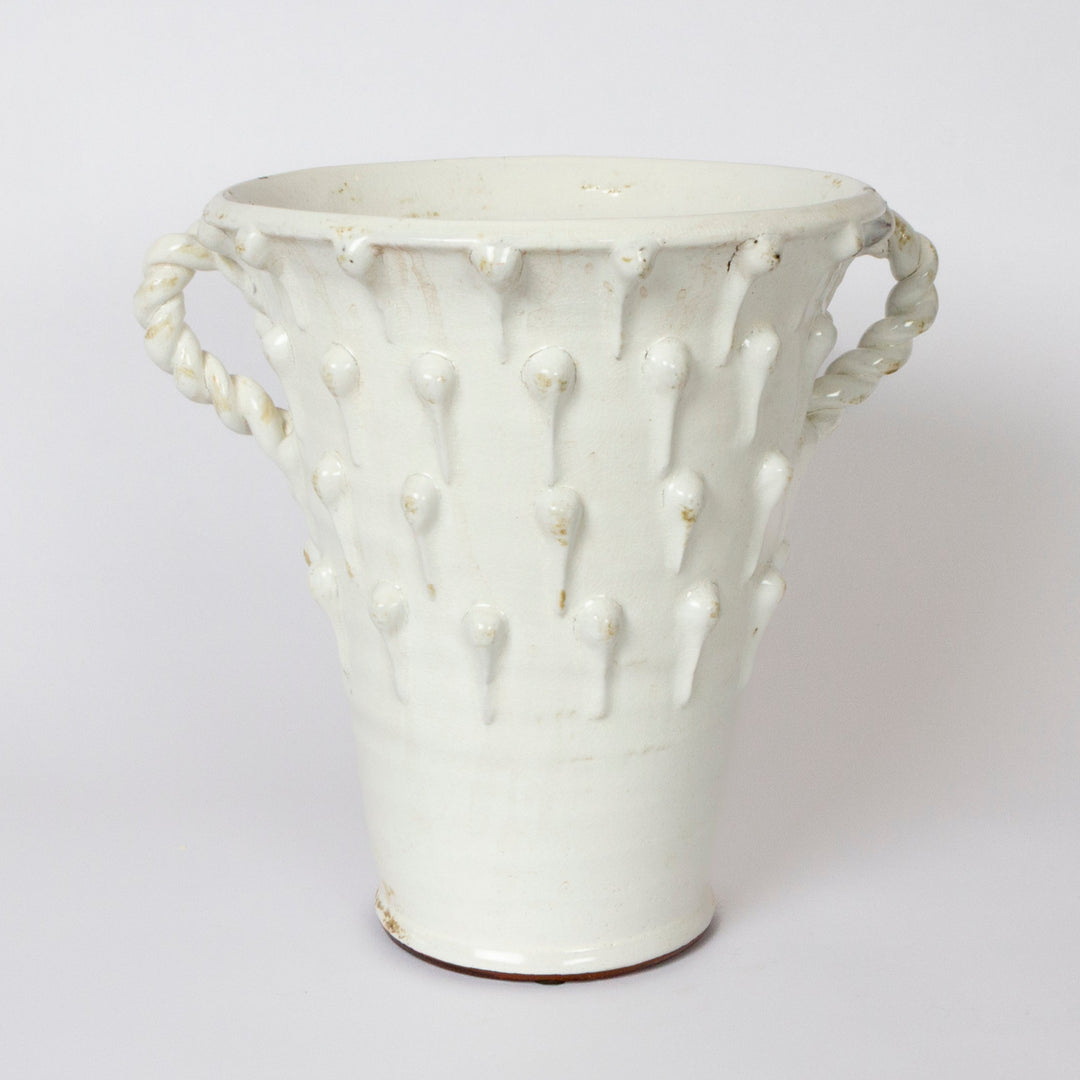 A white ceramic vase with a textured, ribbed body featuring vertical raised dots and rope-style side handles, shown against a plain light gray background.