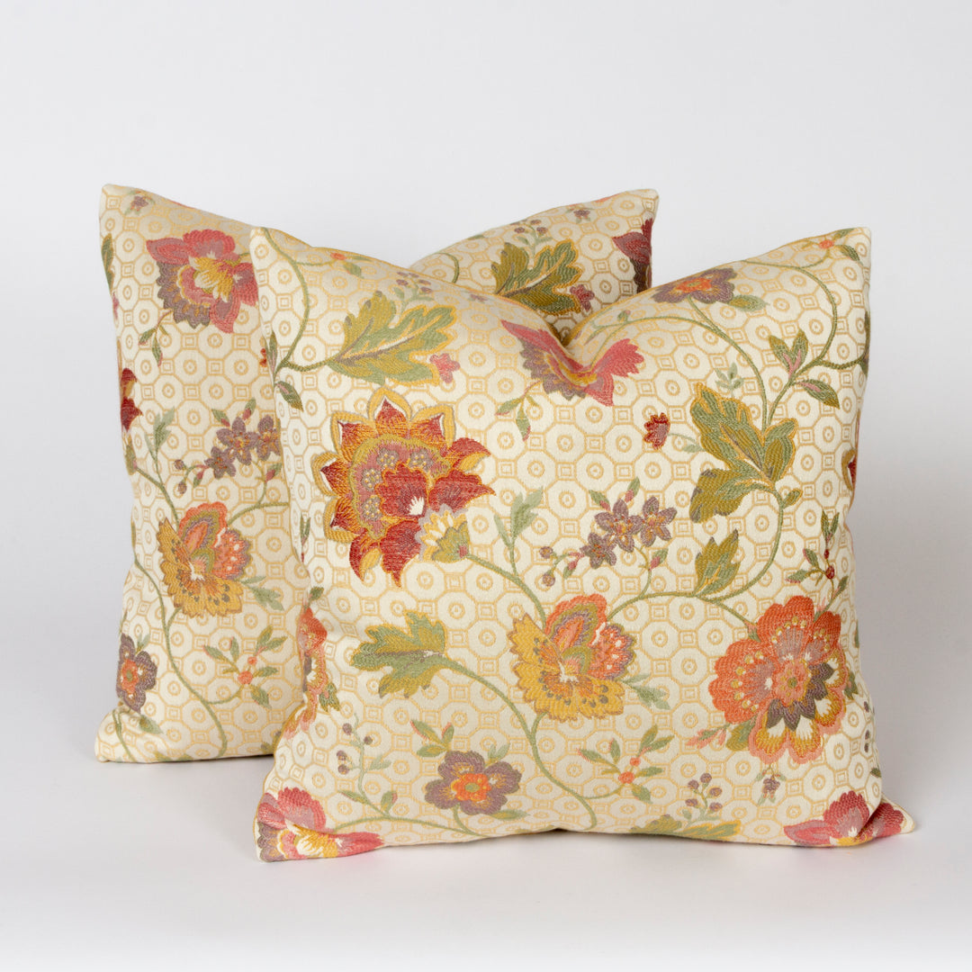 Two square decorative throw pillows with a vintage floral pattern on a cream background, displayed against a light gray studio backdrop.