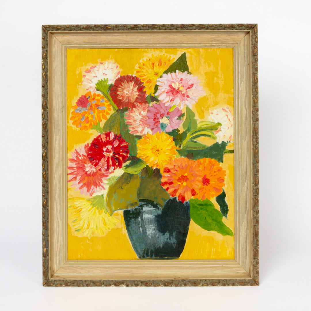 Framed floral painting featuring a bouquet of colorful flowers in a dark vase against a bright yellow background, set in a light wood frame.