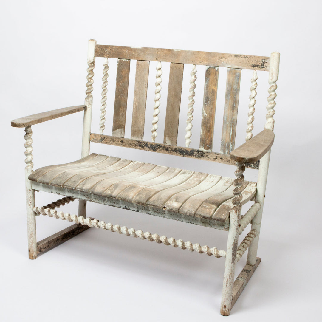A rustic wooden rocking bench with a distressed white and natural wood finish, featuring spiral bead spindles on the arms and backrest, photographed on a seamless white background.